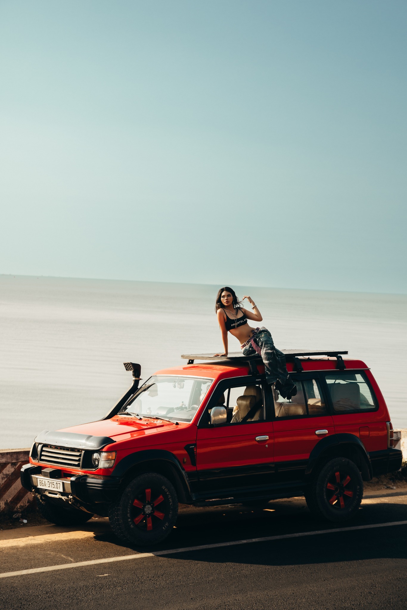 Khách tạo dáng trên xe Jeep đỏ bên biển Mũi Né